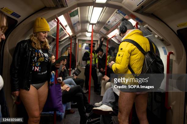 Two participants of the "No Trousers Tube Ride" are seen acting normal without wearing trousers inside the train carriage on London underground. "No...