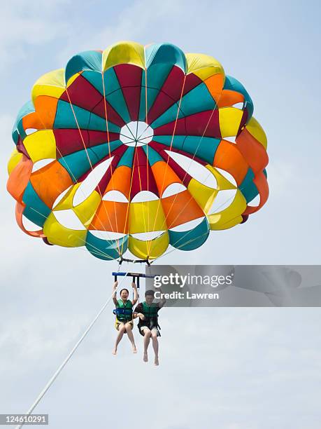 couple are parasailing in sky. - parasailing imagens e fotografias de stock