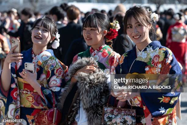 Women dressed in kimonos smile after attending a ceremony at Todoroki Arena to mark "Coming of Age Day" to honour people who turn 20 this year to...