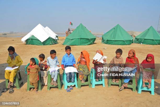 Internally displaced flood-affected children attend a mobile school class near makeshift camp in the flood-hit area of Dera Allah Yar in Jaffarabad...