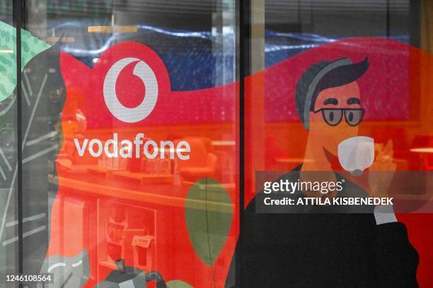 The logo of mobile operator Vodafone is seen on a window at the company's headquarters in Budapest on January 9, 2022. - Vodafone announced on...