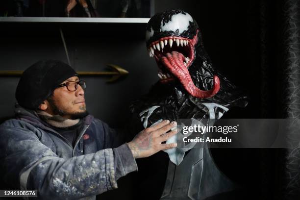 Sculptor Ramiro Sirpa looks at his sculpture of the character Venom from the Marvel universe made in his workshop in La Paz, Bolivia on December 22,...