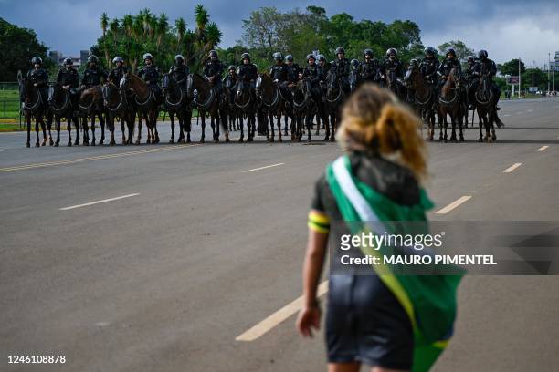 Demonstrator shouts at security forces while a camp set up by supporters of Brazil's far-right ex-president Jair Bolsonaro in front of the Army...