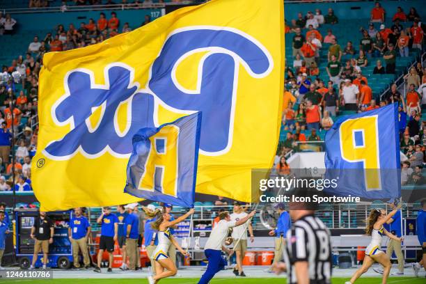 Pittsburgh cheerleaders run on the field carrying Pitt flags before an college football game between the Pittsburgh Panthers and the University of...