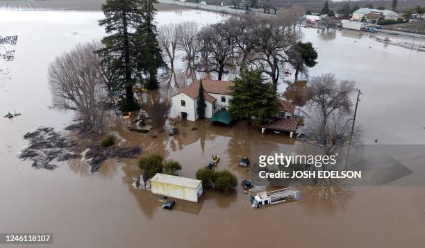 This aerial view shows a flooded home partially underwater in Gilroy, California, on January 9, 2023. - A massive storm called a bomb cyclone" by...