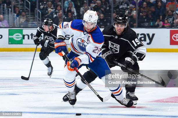Darnell Nurse of the Edmonton Oilers skates with the puck with pressure from Alex Iafallo of the Los Angeles Kings during the second period at...