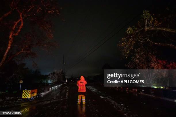 Firefighters block the CA 192 Foothill road while the Arroyo Paredon Creek overflows due to heavy rainfall in the area on January 9 in Carpinteria ,...