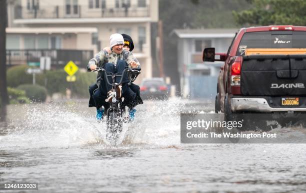 Kids bike through streets flooded along Aptos Beach Drive near the Rio Del Mar State Beach after another powerful storm of rains and high wind hits...