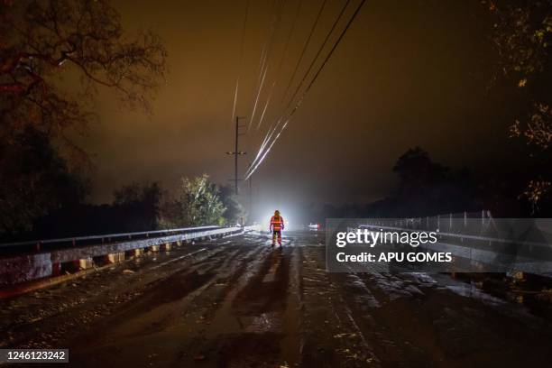 Firefighters block the CA 192 Foothill road while the Arroyo Paredon Creek overflows due to heavy rainfall in the area on January 9 in Carpinteria ,...