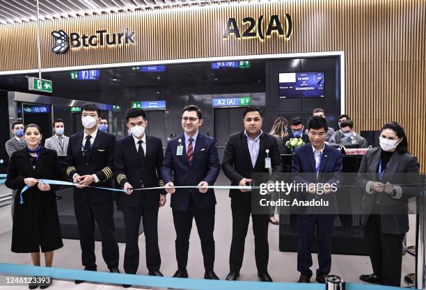 Flight crew cut a ribbon in front of the boarding gate before the first flight from Istanbul to Guangzhou as China re-opens its borders for the first...