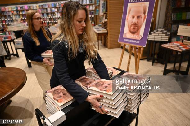 Booksellers carry copies of "Spare" by Britain's Prince Harry, Duke of Sussex, at Waterstones' flagship Piccadilly bookshop on the day of its release...