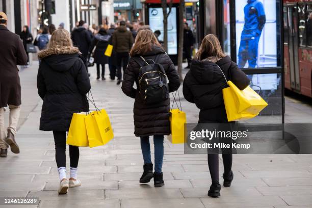 Shoppers with yellow Selfridges shopping bags out on Oxford Street on 9th January 2023 in London, United Kingdom. Oxford Street is a major retail...