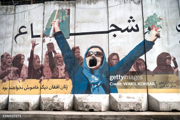 Wall mural of women with a writing "Afghan women will not be silent anymore" is depicted along a street in Kabul on January 10, 2023.