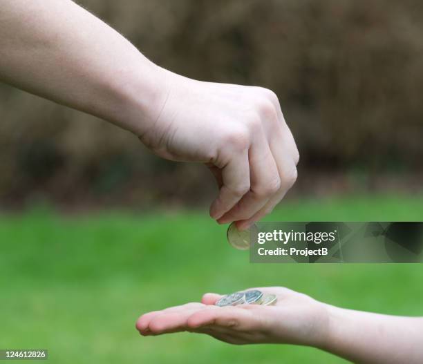 parents hand giving pocket money to child - allowance stock pictures, royalty-free photos & images