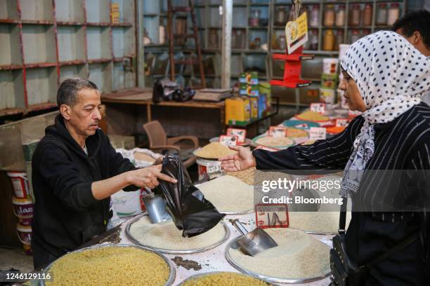 Customer hands over an Egyptian pound banknote for a purchase at Al-Monira food market in the Imbaba district of Giza, Egypt, on Saturday, Jan. 7,...