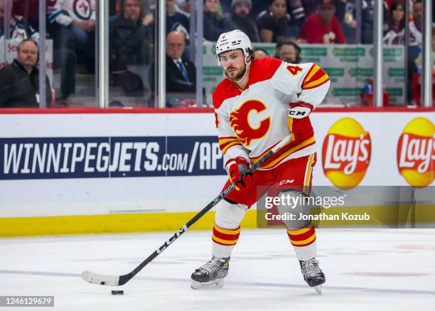 Rasmus Andersson of the Calgary Flames plays the puck during first period action against the Winnipeg Jets at Canada Life Centre on January 03, 2023...