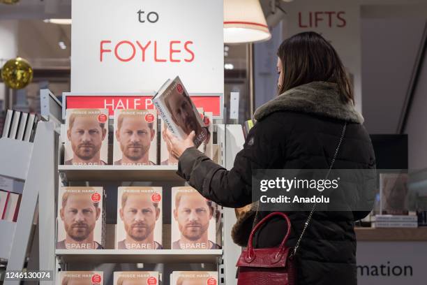 Customer holds Prince Harry's memoir 'Spare' at a bookshop in central London on the day of its official release in London, United Kingdom on January...