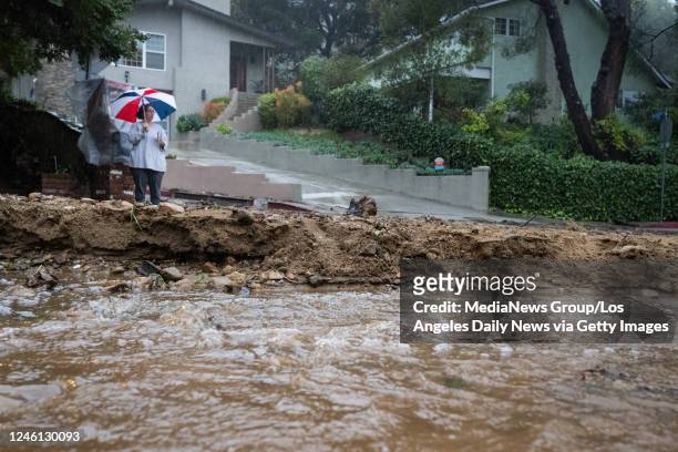Los Angeles, CA A resident keeps watch on Fredonia Drive in Studio City where a mudslide is blocking the road during the storm on Tuesday, January...