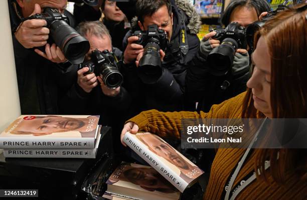 Members of the press gather round to take photographs of copies of "Spare" by Prince Harry as they go on sale at one minutes after midnight in WH...