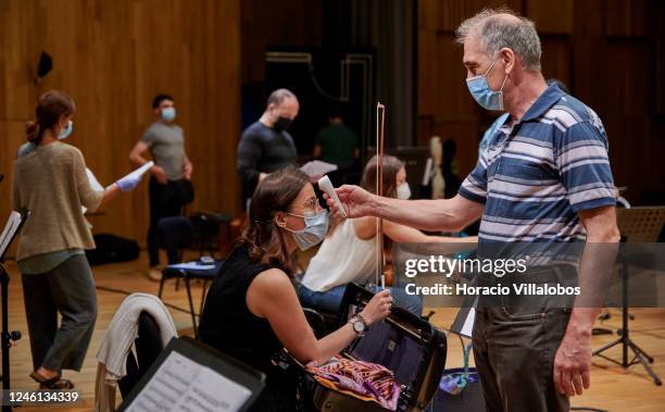 The conductor of the Cascais & Oeiras Chamber Orchestra, Maestro Nikolay Lalov, takes a member's body temperature during a rehearsal in the Auditório...