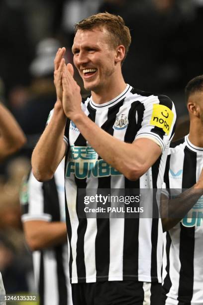 Newcastle United's English defender Dan Burn applauds fans on the pitch after the English League Cup quarter final football match between Newcastle...