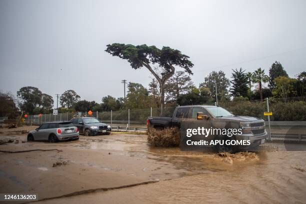 Truck tows a car that got stuck in the mud as a result of San Ysidro Creek overflowing due to heavy rainfall in the area on January 10, 2023 in...