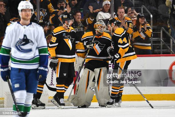 Dustin Tokarski of the Pittsburgh Penguins celebrates with teammates after a 5-4 win over the Vancouver Canucks at PPG PAINTS Arena on January 10,...