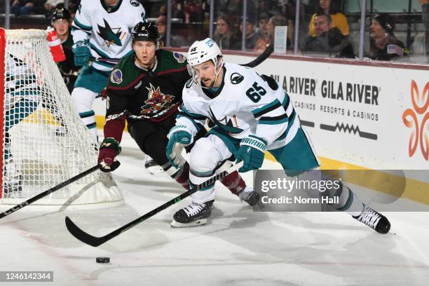 Erik Karlsson of the San Jose Sharks skates with the puck while being defended by Jakob Chychrun of the Arizona Coyotes during the first period at...