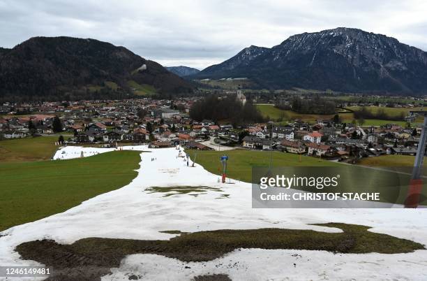 Patchy artificial snow hill is pictured near the Bavarian village of Ruhpolding, southern Germany, on January 11, 2023. - Many ski resorts across...