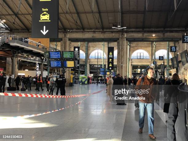 Passengers are seen waiting at the Gare du Nord train station as French police cordon off an area after a knife-wielding suspect injured six people,...