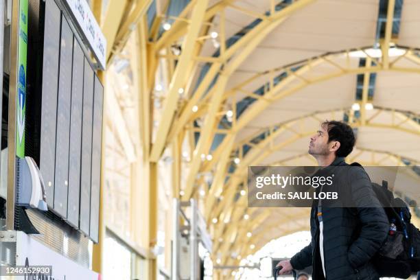 Traveler looks at a flight information display listing cancelled and delayed flights due to an FAA outage that grounded flights across the US at...