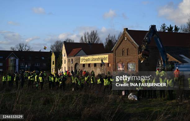 Employees of a security service build a cordon on behalf of German energy supplier RWE around the village of Luetzerath, western Germany, on January...