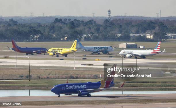 Airliners wait for takeoff in a queue at runways 36L and 36R at Orlando International Airport, Wednesday, Jan. 11 after the FAA grounded all U.S....