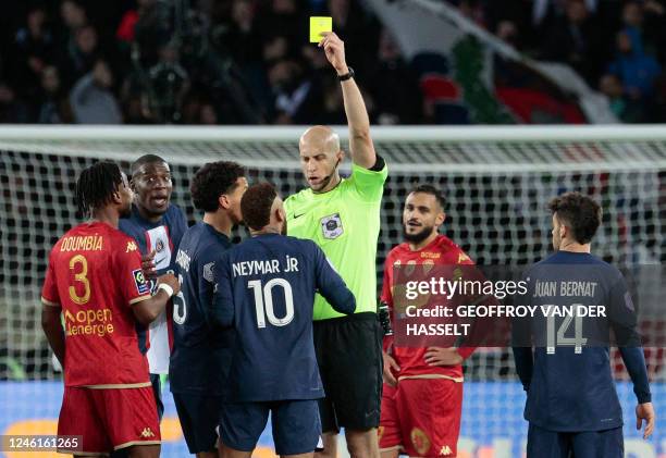 French referee Eric Wattellier gives a yellow card to Paris Saint-Germain's Brazilian forward Neymar during the French L1 football match between...