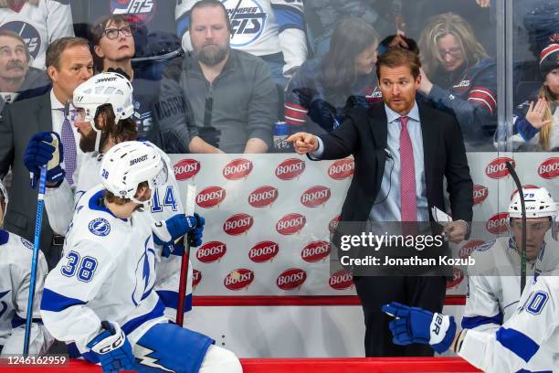 Assistant coach Jeff Halpern of the Tampa Bay Lightning delivers some instructions to Brandon Hagel during a third period stoppage of play against...