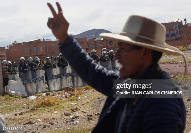 Police shadow demonstrators gathering at a field adjacent to the airport in the Andean city of Juliaca, southern Peru, on January 11, 2023. - Peru's...