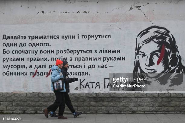 Couple walks past a mural in relation to Kateryna Handziuk seen in Lviv's center. Kateryna Handziuk was a Ukrainian civil rights and anti-corruption...