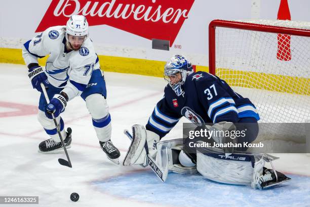 Anthony Cirelli of the Tampa Bay Lightning plays the puck in front of goaltender Connor Hellebuyck of the Winnipeg Jets during third period action at...