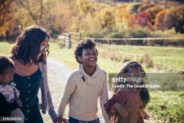 Mother and daughters walking on dirt road