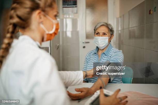 senior woman visited by home care specialist - covid visit stock pictures, royalty-free photos & images