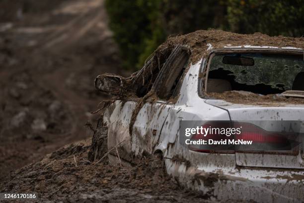 Car that was smashed by a landslide lies mud-bound on a closed road on January 11, 2023 near Fillmore, California. A series of powerful storms...