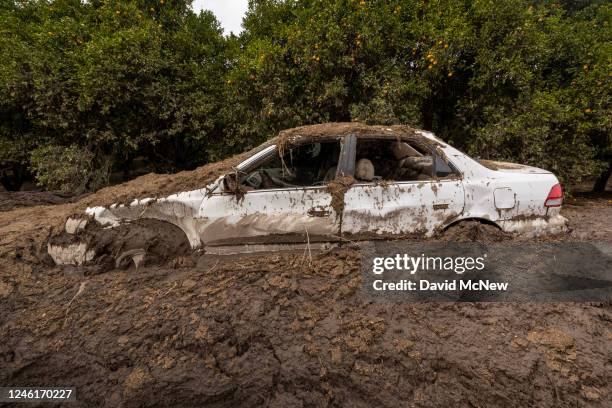 Car that was smashed by a landslide lies mud-bound on a closed road on January 11, 2023 near Fillmore, California. A series of powerful storms...