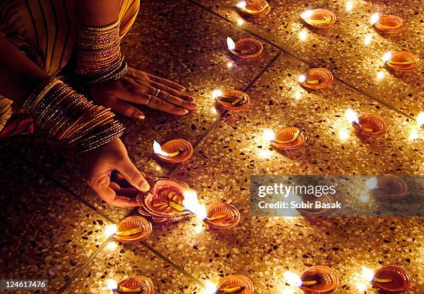 woman hand lighting diva's - diwali 個照片及圖片檔
