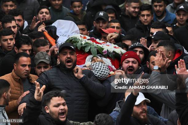 Palestinians carry the body of Samir Aslan during his funeral at Qalandia refugee camp in the occupied West Bank on January 12, 2023. - Israeli...