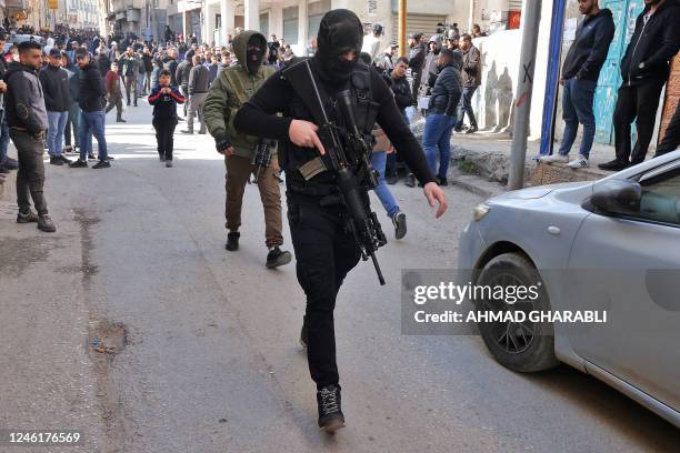 Palestinian gunman attend the funeral of Samir Aslan at Qalandia refugee camp in the occupied West Bank, on January 12, 2023. - Israeli forces killed...
