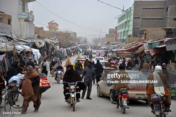 Commuters make their way through a busy market in Kandahar on January 12, 2023.