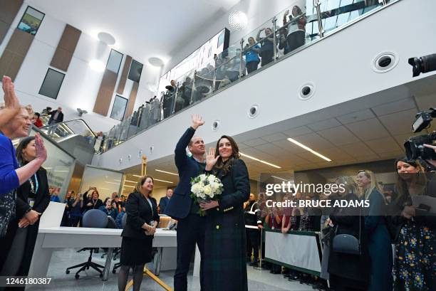 Britain's Prince William , Prince of Wales, and Britain's Catherine , Princess of Wales, wave at staff during a visit to the Royal Liverpool...