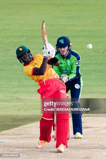 Zimbabwe's Clive Madande plays a shot as Ireland's wicketkeeper Stephen Doheny looks on during the first T20 international cricket match between...