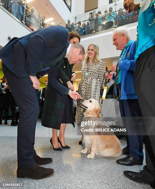 Britain's Prince William, Prince of Wales and Britain's Catherine, Princess of Wales , meet therapy dog, golden retriever "Rosie" and handler Jim...
