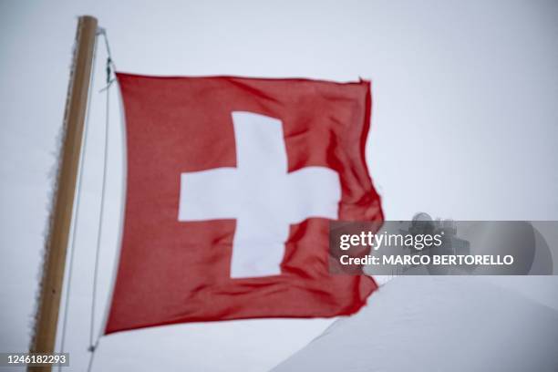 Flag of Switzerland is displayed near the Jungfraujoch, 3500 meters high in the Swiss Alps, above the village of Wengen, on January 12, 2023.